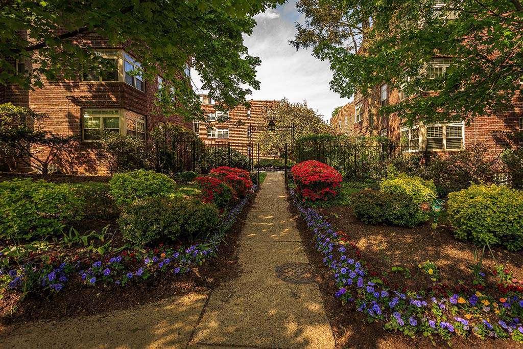 Beautifully landscaped entrance surrounded by flowers at Sedgwick Gardens apartments for rent